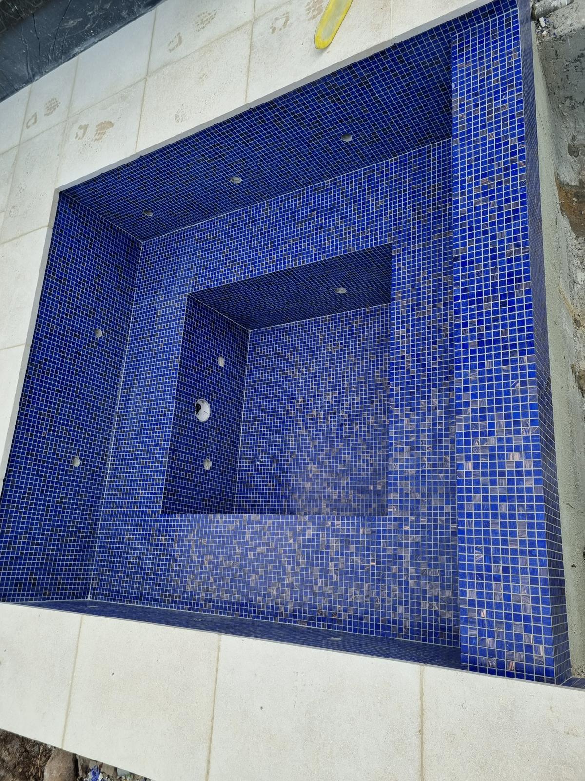 Square spa with deep blue glass mosaic tiling